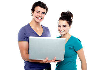 Image showing Charming teen couple holding a laptop