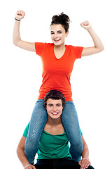 Image showing Excited pretty girl enjoying riding on his friends shoulder