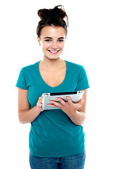 Image showing Pretty young brunette using wireless tablet device