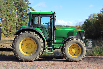 Image showing Green tractor by field