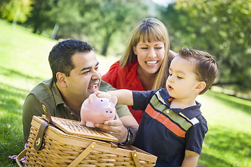 Image showing Mixed Race Couple Give Their Son a Piggy Bank at the Park