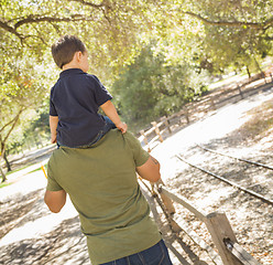 Image showing Mixed Race Son Enjoy a Piggy Back in the Park with Dad