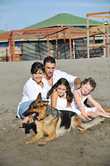 Image showing happy family playing with dog on beach