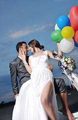 Image showing just married couple on the beach ride white scooter