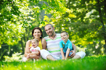 Image showing happy young couple with their children have fun at park