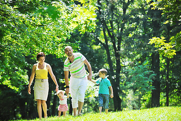 Image showing happy young couple with their children have fun at park