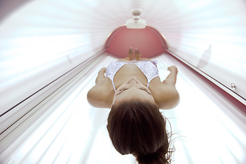 Image showing Beautiful young woman tanning in solarium