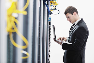 Image showing businessman with laptop in network server room