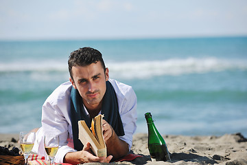 Image showing man reading book at beach