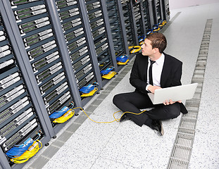 Image showing businessman with laptop in network server room