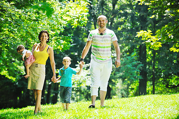 Image showing happy young couple with their children have fun at park