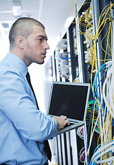 Image showing businessman with laptop in network server room