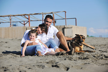 Image showing happy family playing with dog on beach