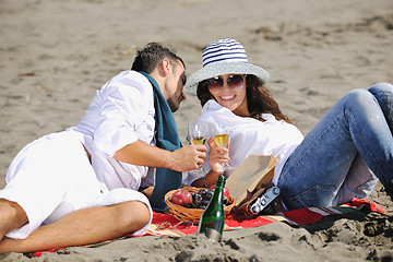 Image showing young couple enjoying  picnic on the beach