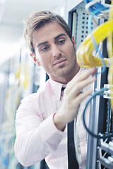 Image showing businessman with laptop in network server room