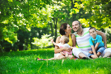 Image showing happy young couple with their children have fun at park