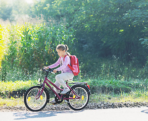Image showing schoolgirl traveling to school on bicycle