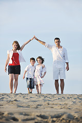 Image showing family on beach showing home sign