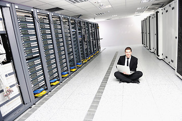 Image showing businessman with laptop in network server room