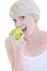 Image showing happy  young  woman eat green apple isolated  on white