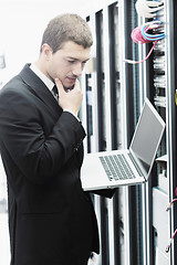 Image showing businessman with laptop in network server room