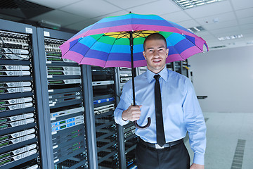 Image showing businessman hold umbrella in server room