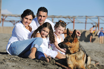 Image showing happy family playing with dog on beach