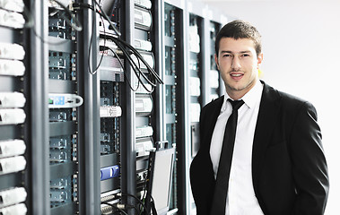 Image showing businessman with laptop in network server room