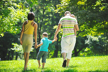 Image showing happy young couple with their children have fun at park