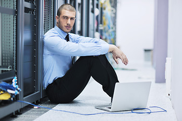 Image showing businessman with laptop in network server room