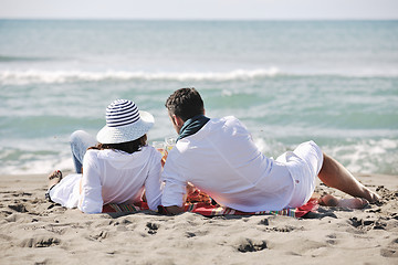 Image showing young couple enjoying  picnic on the beach