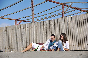 Image showing young couple enjoying  picnic on the beach