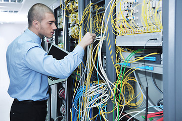 Image showing businessman with laptop in network server room