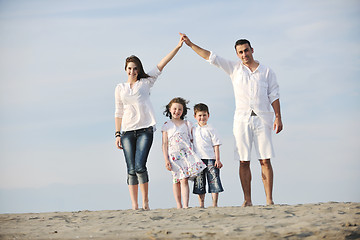 Image showing family on beach showing home sign