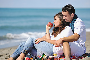 Image showing young couple enjoying  picnic on the beach