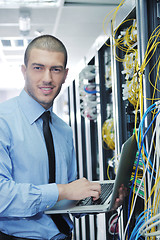 Image showing businessman with laptop in network server room