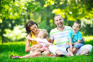 Image showing happy young couple with their children have fun at park