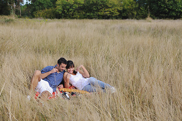 Image showing happy couple enjoying countryside picnic in long grass