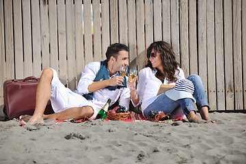 Image showing young couple enjoying  picnic on the beach