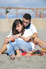 Image showing young couple enjoying  picnic on the beach