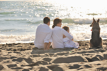 Image showing happy family playing with dog on beach