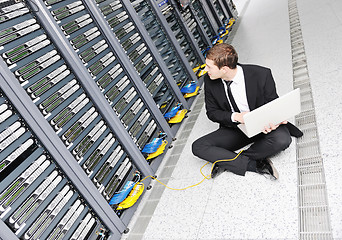 Image showing businessman with laptop in network server room