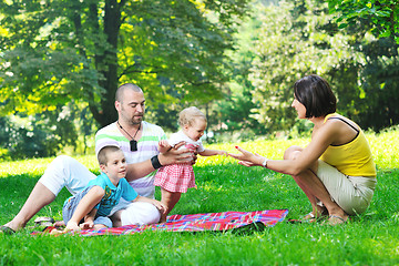 Image showing happy young couple with their children have fun at park