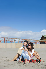 Image showing young couple enjoying  picnic on the beach