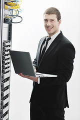 Image showing businessman with laptop in network server room