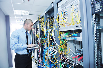 Image showing businessman with laptop in network server room