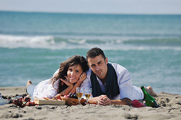 Image showing young couple enjoying  picnic on the beach