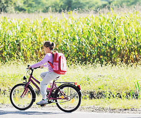 Image showing schoolgirl traveling to school on bicycle