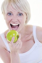 Image showing happy  young  woman eat green apple isolated  on white