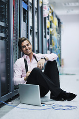 Image showing businessman with laptop in network server room